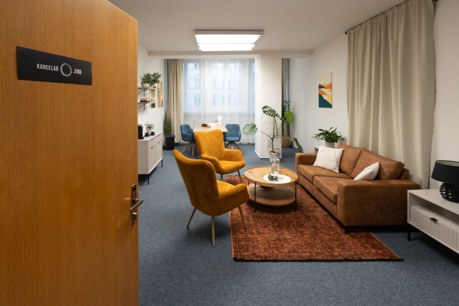 The entrance to the Jung office in Brno and a seating area with orange armchairs and a sofa